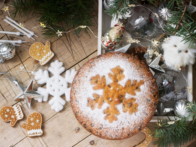 Bolo de frutas tradicional do Natal em uma caixa com brinquedos de Natal e ramos de abeto.