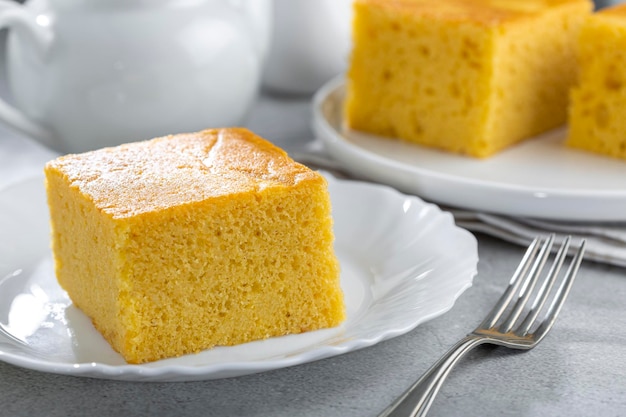 Bolo de fubá fatiado em cima da mesa