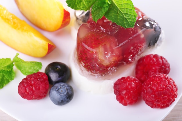 Bolo de geleia de morango com frutas e bagas no prato sobre fundo de madeira