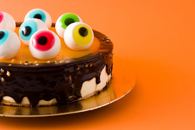 Foto bolo de halloween com decoração de olhos doces em laranja