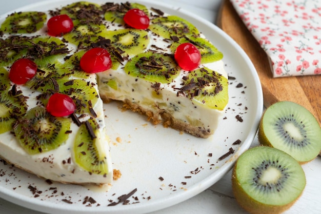 Bolo de iogurte e kiwi com base de biscoito decorado com chocolate ralado