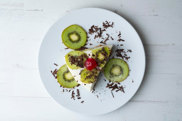 Bolo de iogurte e kiwi com base de biscoito decorado com chocolate ralado