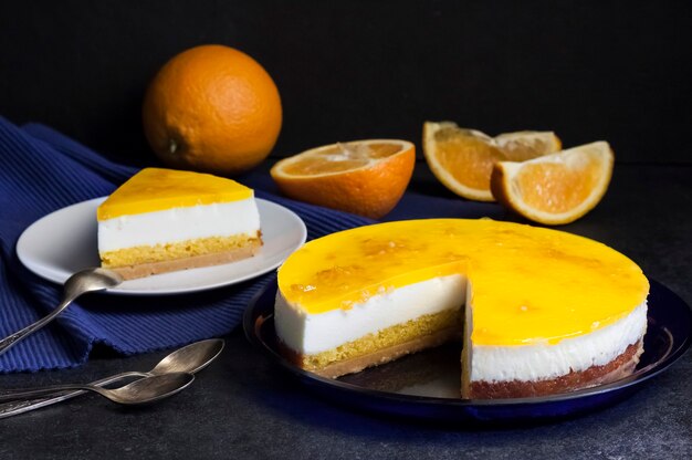 Bolo de laranja com mousse de creme e geleia de laranja em fundo escuro