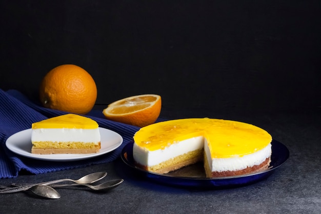 Bolo de laranja com mousse de creme e geleia de laranja em fundo escuro