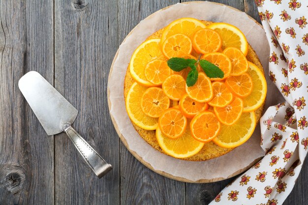 Bolo de laranja e tangerina com polenta, de cabeça para baixo na velha superfície de madeira. vista do topo. foco seletivo.