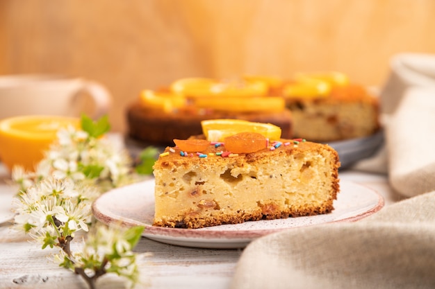 Bolo de laranja e uma xícara de café em uma madeira branca