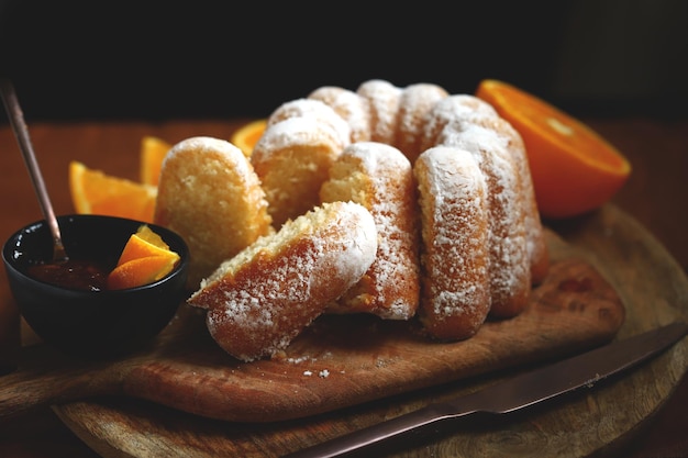 Bolo de laranja macio e fofo com açúcar de confeiteiro em uma placa de madeira