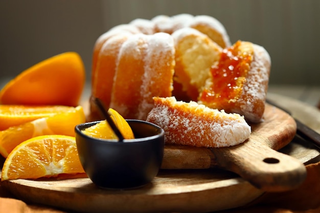 Bolo de laranja macio e fofo com açúcar de confeiteiro em uma placa de madeira