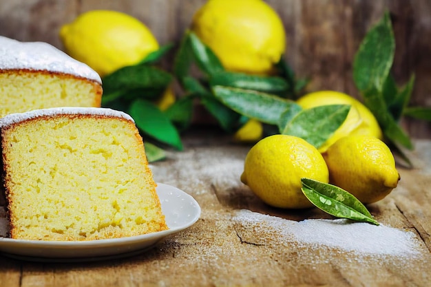 Bolo de limão caseiro com frutas cítricas em açúcar na mesa de madeira