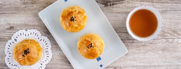 Bolo de lua bolo de massa de gema de lua para o conceito de design de vista superior do feriado do Festival MidAutumn na mesa de madeira brilhante com espaço de cópia tiro aéreo plano