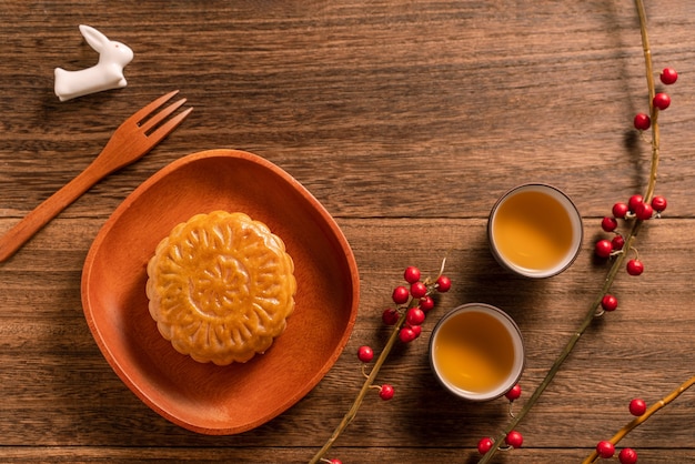 Bolo de lua criativo design de mesa mooncake - pastelaria tradicional chinesa com xícaras de chá, conceito mid-autumn festival, vista de cima, lay plana.