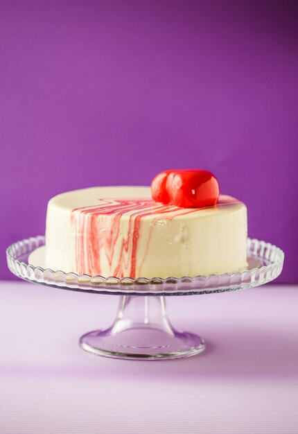 Bolo de luxo e elegante branco e vermelho sobre parede roxa