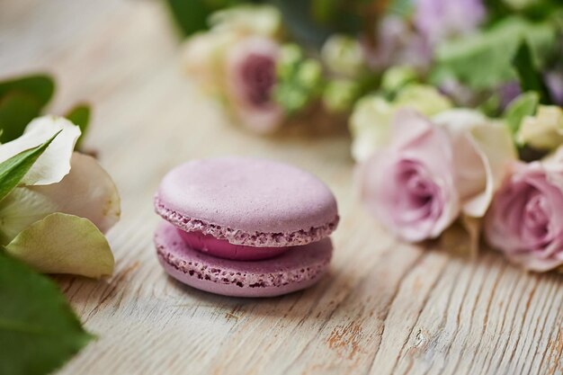 Bolo de macaroon roxo com rosas no tampo da mesa