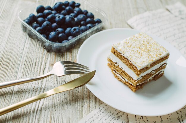 Bolo de mel com mirtilo em um pires branco sobre a mesa