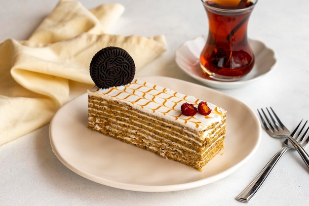 Bolo de mel em um fundo branco Bolo de mel em camadas cheio de creme de perto