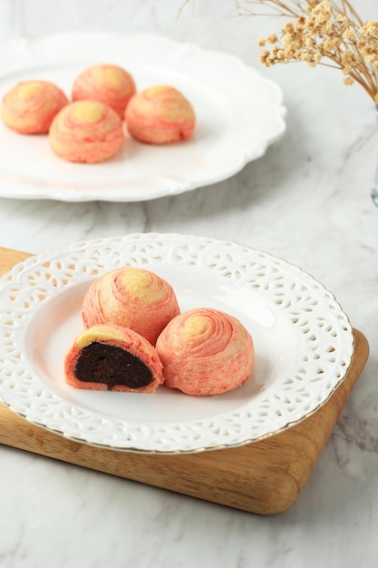 Bolo de mil camadas espiral de feijão vermelho, bolos de lua estilo pastelaria recheados com pasta de feijão vermelho adoçado. Padaria Conceito Branco