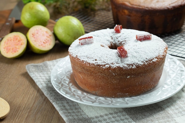 Bolo de milho brasileiro feito com um tipo de farinha de milho Fuba recheado com goiabada Em uma mesa de festa de madeira Doces típicos da festa junina Bolo de fubá