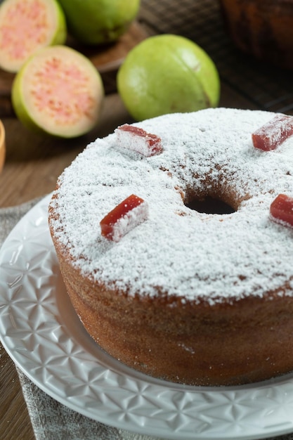 Foto bolo de milho brasileiro feito com um tipo de farinha de milho fuba recheado com goiabada em uma mesa de festa de madeira doces típicos da festa junina bolo de fubá