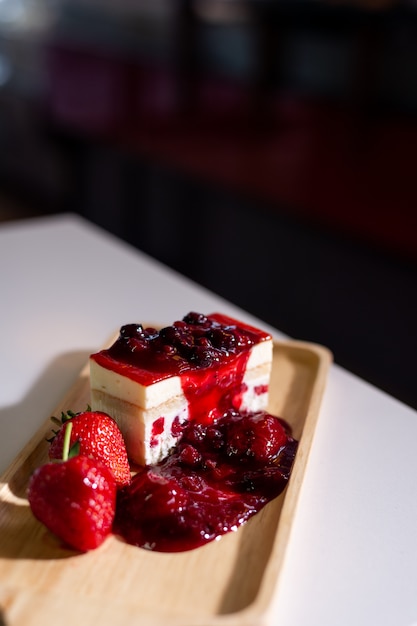 Bolo de morango na placa de madeira no mini café