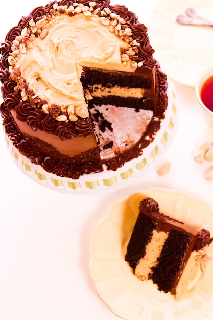 Bolo de mousse de manteiga de amendoim com duas camadas de bolo de chocolate, recheado e coberto com mousse de manteiga de amendoim e coberto com creme de manteiga de chocolate.