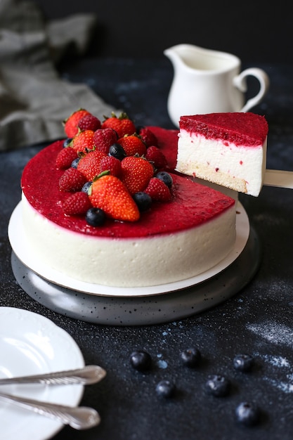 Bolo de mousse fatiado com frutas vermelhas por cima