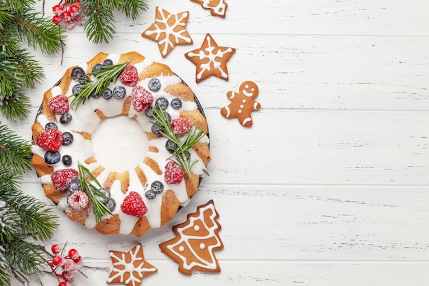 bolo de Natal com bagas e biscoitos de pão de gengibre Top vista plana com espaço para suas saudações