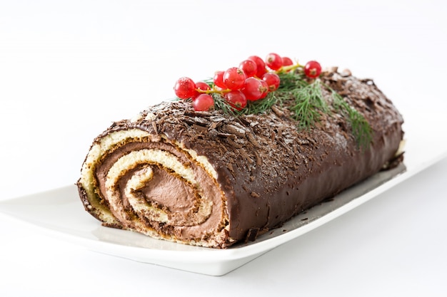 Foto bolo de natal de chocolate yule log com groselha isolada no branco