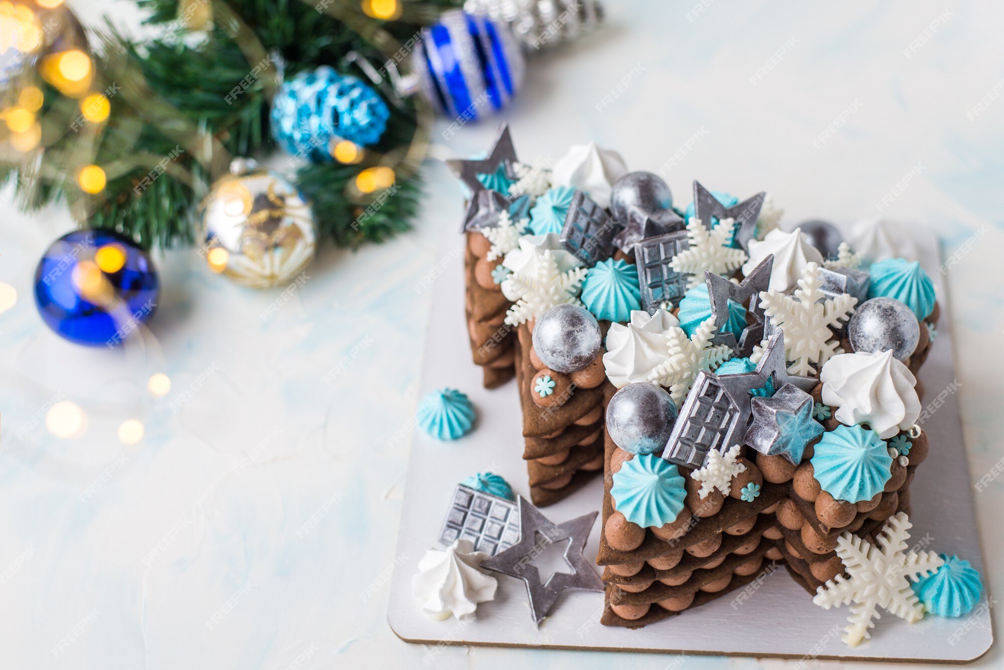 Bolo de natal em forma de árvore de natal. bolo de natal com esferas de chocolate e flocos de neve. chocolate com decoração azul. | Foto Premium Bolo de natal em forma de árvore de natal. bolo de natal com esferas de chocolate e flocos de neve. chocolate com decoração azul. | Foto Premium