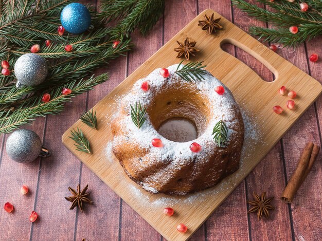 Bolo de Natal em forma de uma coroa de flores com enfeites de Natal.