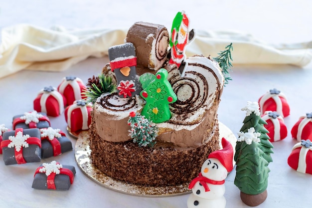 Bolo de natal preparado com pasta de açúcar com árvore de natal de papai noel e figuras de presente nele