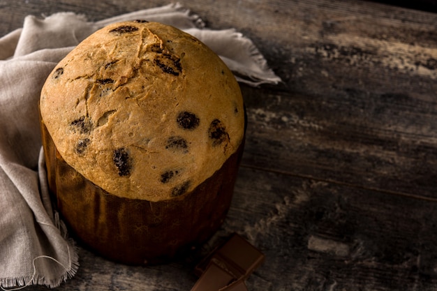 Bolo de panetone de chocolate de natal com natal decorado na mesa de madeira copie o espaço