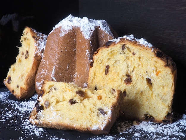 Bolo de panetone de Natal italiano inteiro e fatias com frutas cristalizadas e passas Closeup