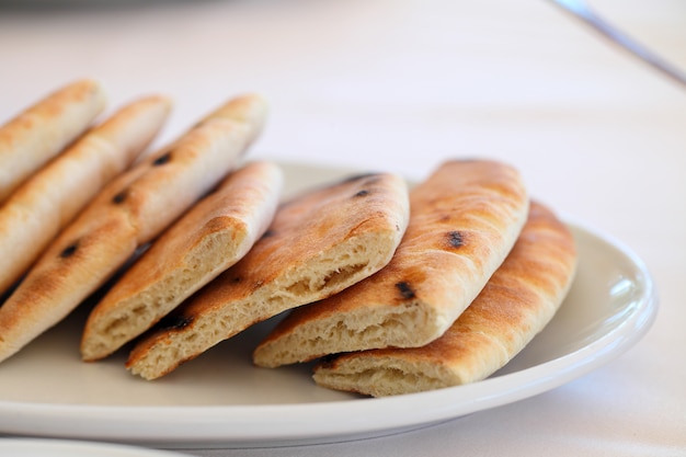 Bolo de pão liso cortado em pedaços em um prato.