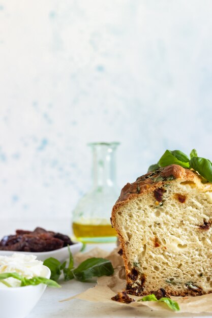 Bolo de pão salgado com tomate seco, mussarela e manjericão. Foco seletivo.