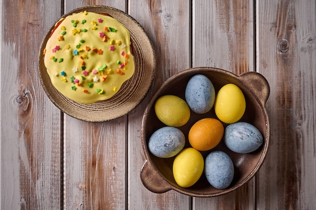 Bolo de Páscoa caseiro e ovos multicoloridos em bandeja preta