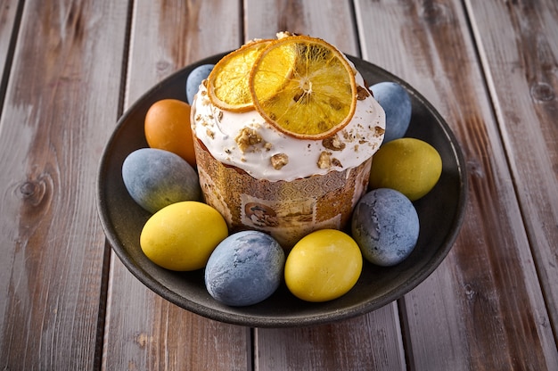 Bolo de Páscoa caseiro e ovos multicoloridos em bandeja preta