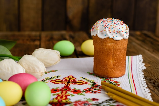 Bolo de Páscoa e ovos coloridos em uma mesa de madeira.