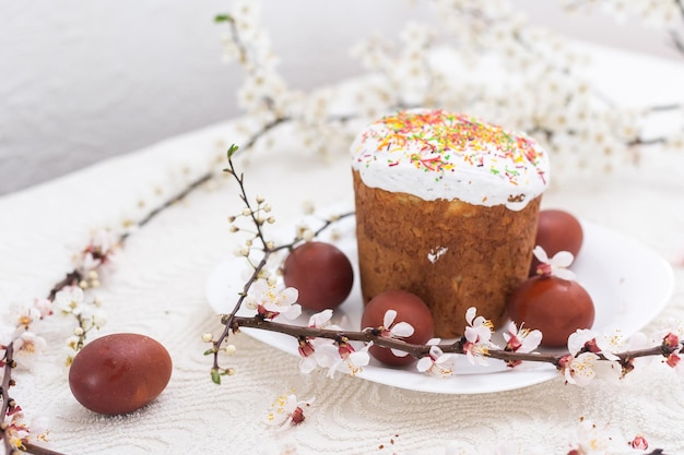 Bolo de Páscoa e ramo de florescência de ovos pintados.