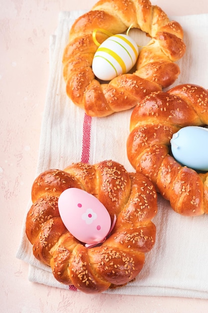 Bolo de Páscoa espanhol Mona de pascua tradicional típico da Espanha com ovos cozidos comidos dentro no fundo da mesa rústica rosa Comida típica da pastelaria espanhola Mona de Pascua Vista superior Mock up