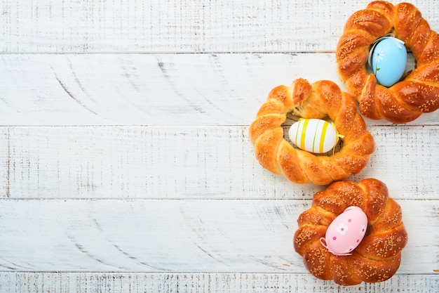 Bolo de Páscoa espanhol Tradicional mona de pascua típico na Espanha com ovos cozidos comidos dentro na mesa de madeira rústica branca Espaço para cópia Vista superior Mock up