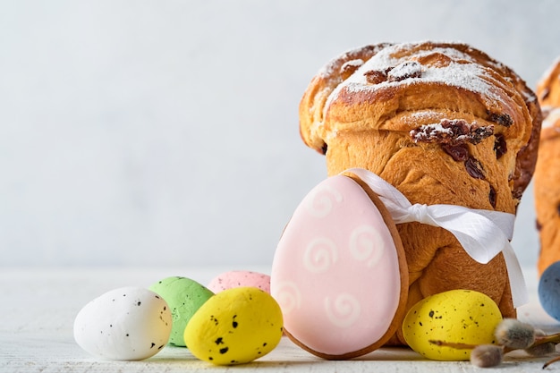 Bolo de Páscoa, ovos brilhantes, pão de gengibre e ramos de salgueiro em uma mesa de Páscoa festiva. Cartão de felicitações.