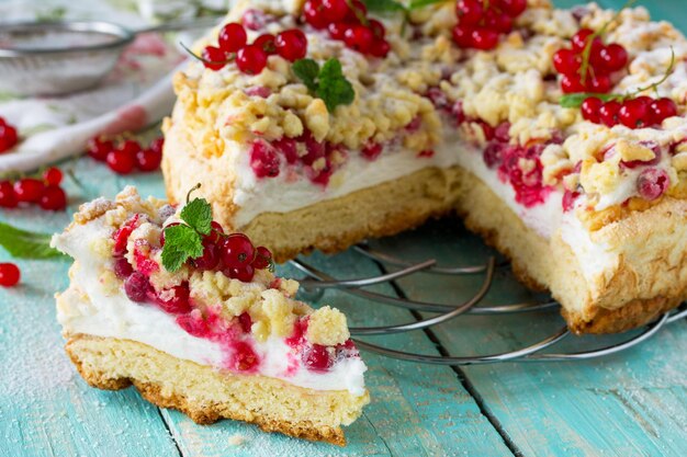 Bolo de pastelaria doce com merengue Pavlov e groselhas frescas de verão Conceito de cozimento de verão