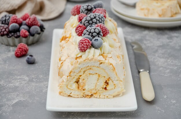 Bolo de Pavlova com rolinho de merengue com creme e frutas vermelhas