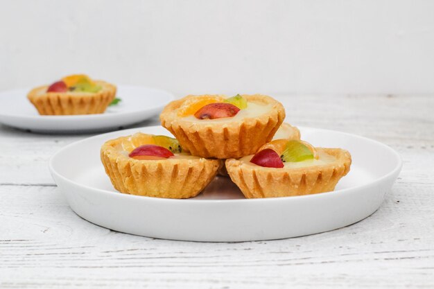 Bolo de pia de frutas pequeno em um fundo branco texturizado kue pia buah