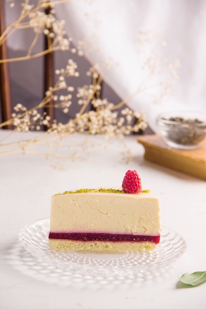 Bolo de queijo com framboesas sobre um fundo claro. copie o espaço. foto vertical