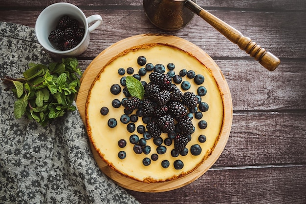 Bolo de queijo com morangos de amêndoa de amoras no fundo de concreto com guardanapo