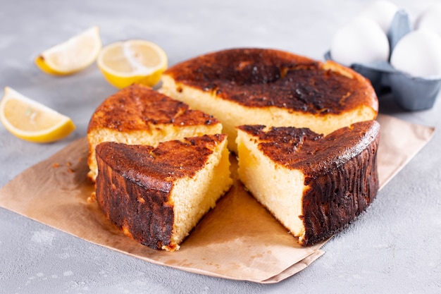 Bolo de queijo de San Sebastian cortado e fatiado para servir em um fundo claro