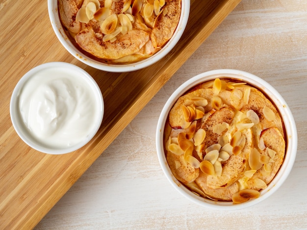 Bolo de queijo na tabela de madeira branca na cozinha. Delicada sobremesa de requeijão com maçãs