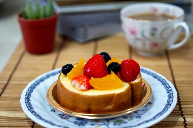 Bolo de rolo de frutas doce misturado em um prato com café quente