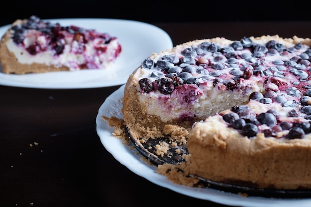 Bolo de torta de frutas vermelhas com groselhas de cerejas em uma tigela de vapor fresco e fatias de fundo quente desfocadas